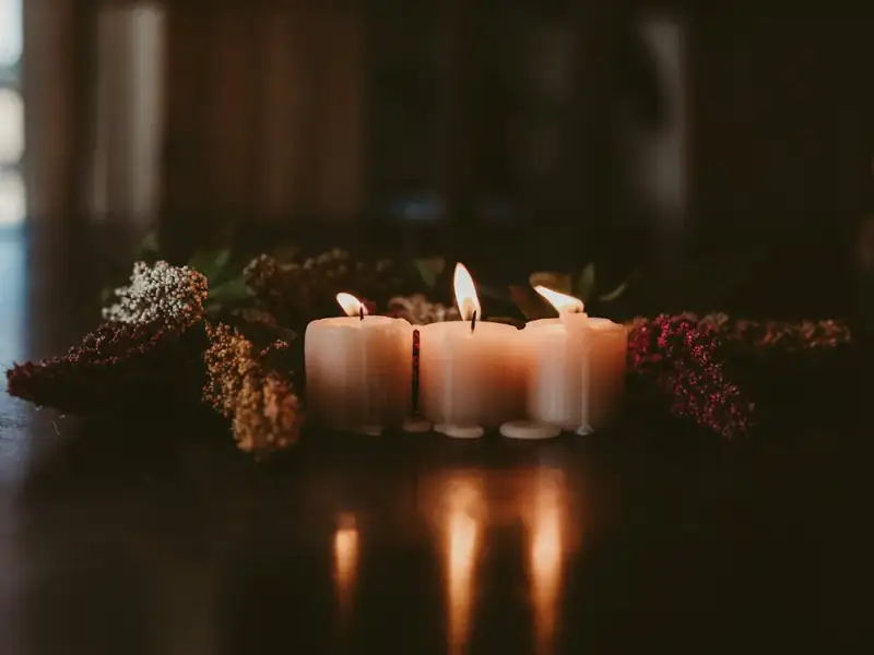 Lit candles and flowers on a wooden table