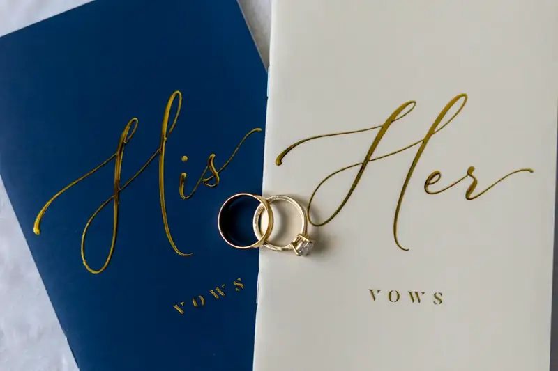 Wedding rings resting on his and hers vow books